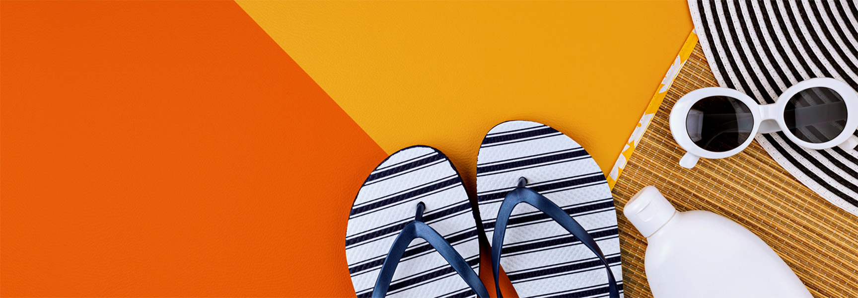 A flat lay image shows blue and white striped flip-flops, a sunscreen bottle, round white sunglasses, and a black and white striped wide-brimmed hat on a background of orange and yellow panels.