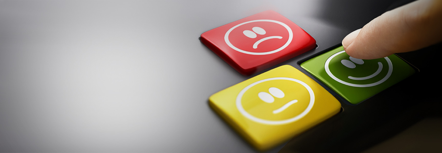 A finger presses a green button with a smiling face. Next to it are a yellow button with a neutral face and a red button with a sad face, representing different mood or satisfaction levels.